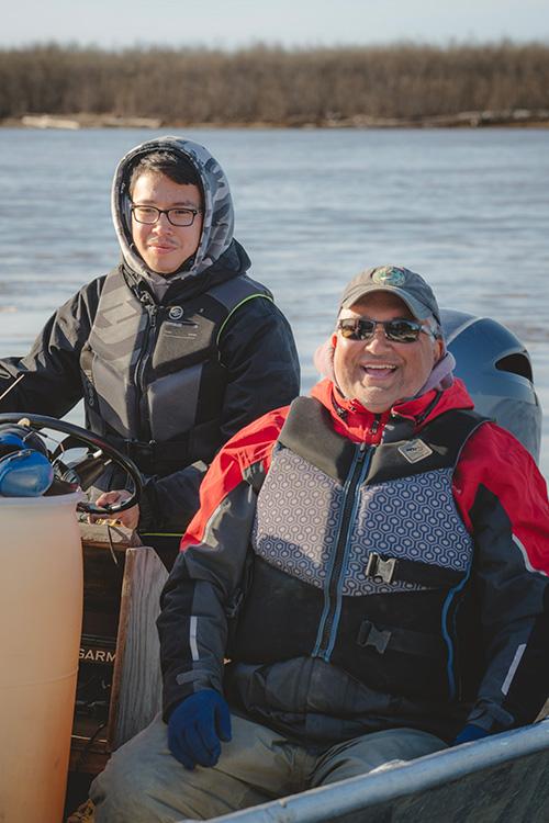 Captain and crew member on boat in water