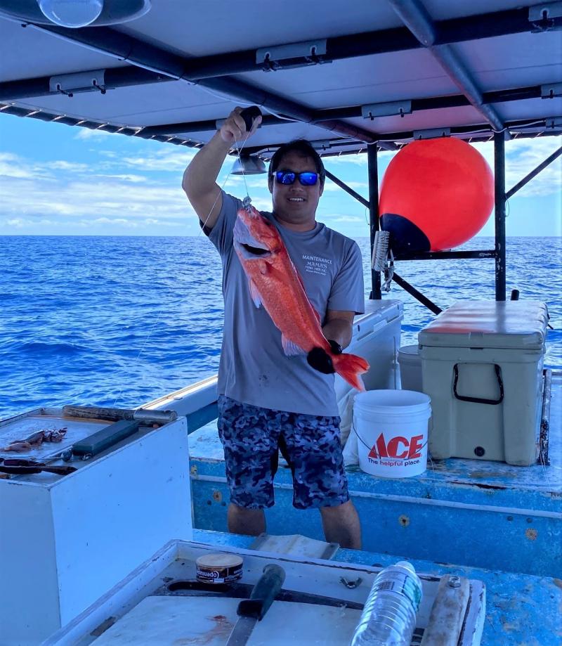 Captain Layne Nakagawa of the F/V Naomi K holding an ehu. Photo courtesy of Pacific Islands Fisheries Group/Fishing Vessel Naomi K.