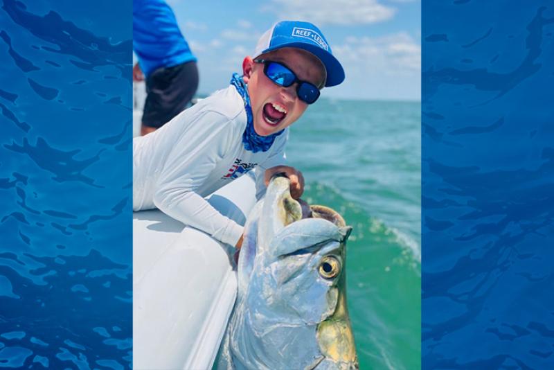 Boy fishing, holding tarpon
