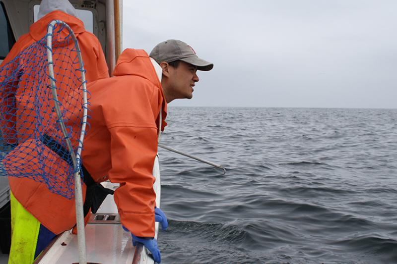 Researcher standing on deck of ship.