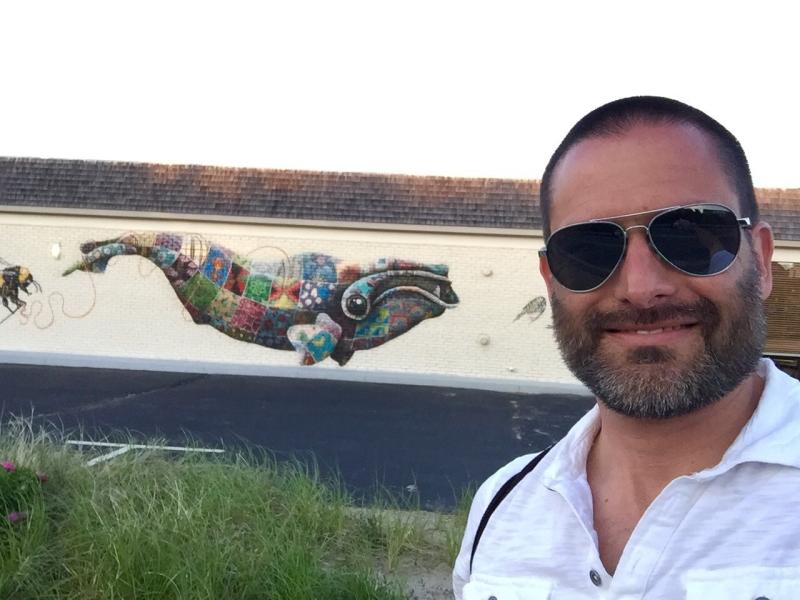 Trevor in Provincetown, Massachusetts in front of a North Atlantic right whale mural painted by wildlife conservation artist Louis Masai to raise awareness about the endangered species.  