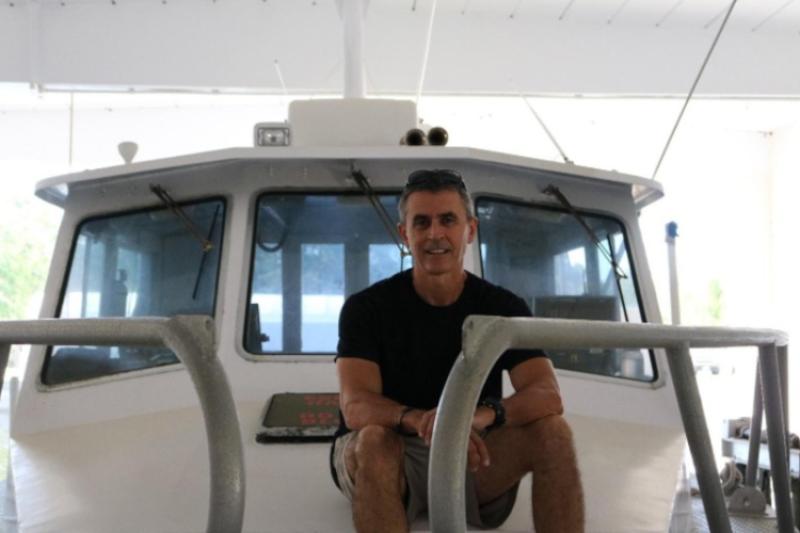 Enric Cortés sitting on the deck of a vessel preparing for fieldwork.
