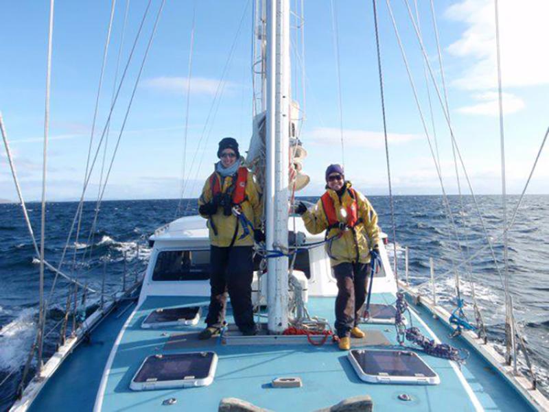 Two scientists stand on boat during marine mammal survey in Scotland