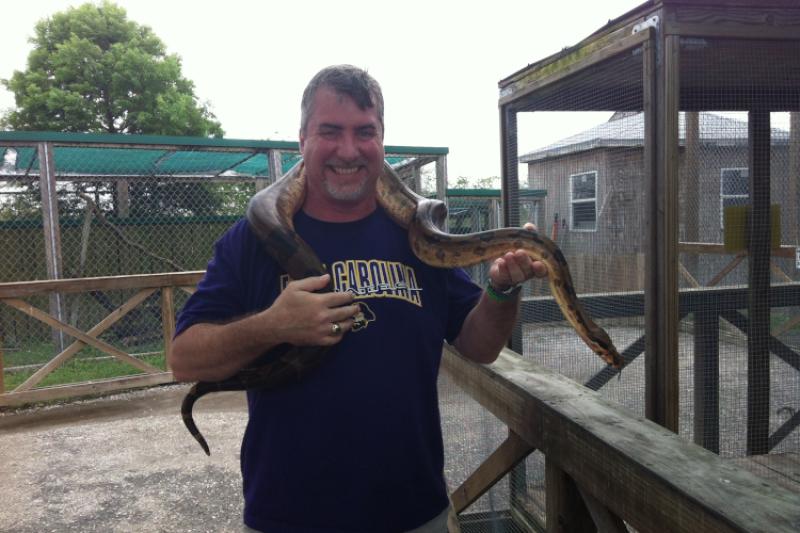 David Gloeckner holding a large constrictor snake.