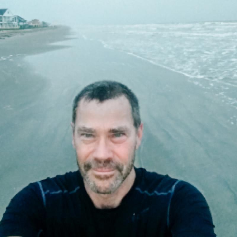 A man smiling on a beach