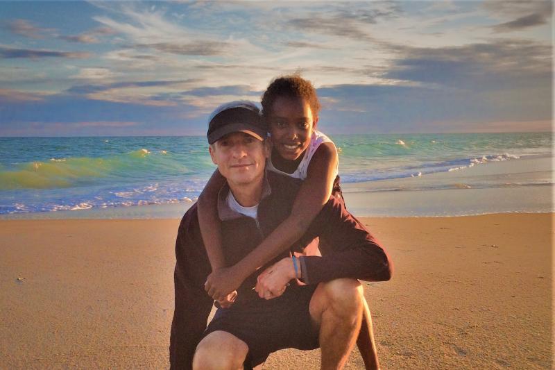 Todd Kellison on beach with his daughter, Bontu.