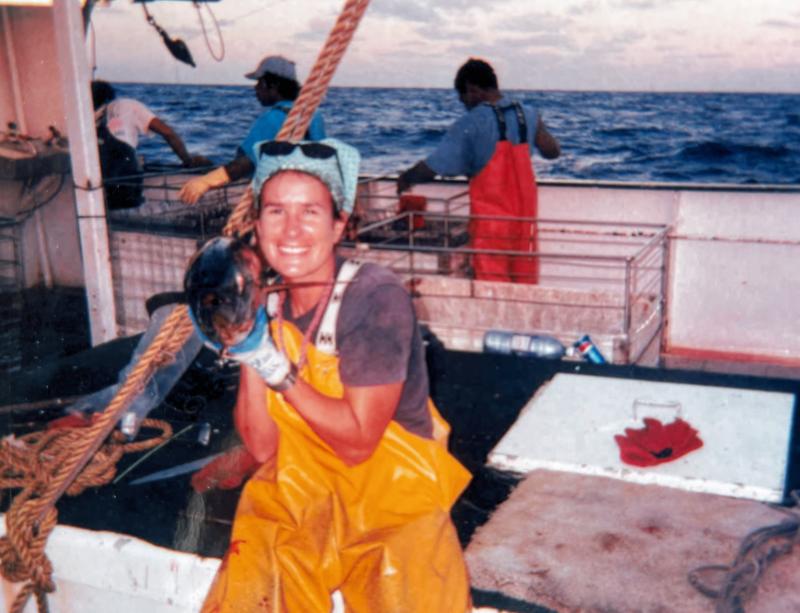 Woman posing with a small tuna onboard ship as a Hawai‘i-based longline observer