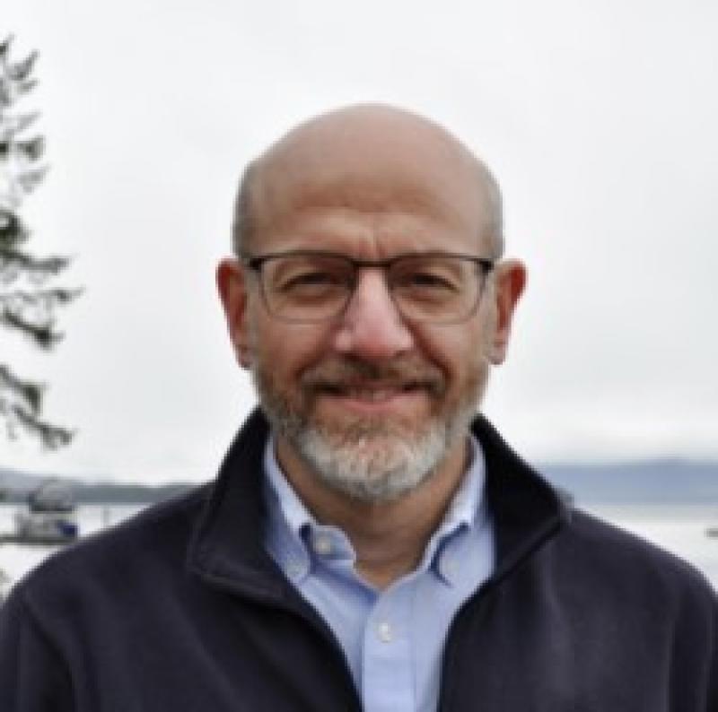 Jon Kurland smiling in front of seashore