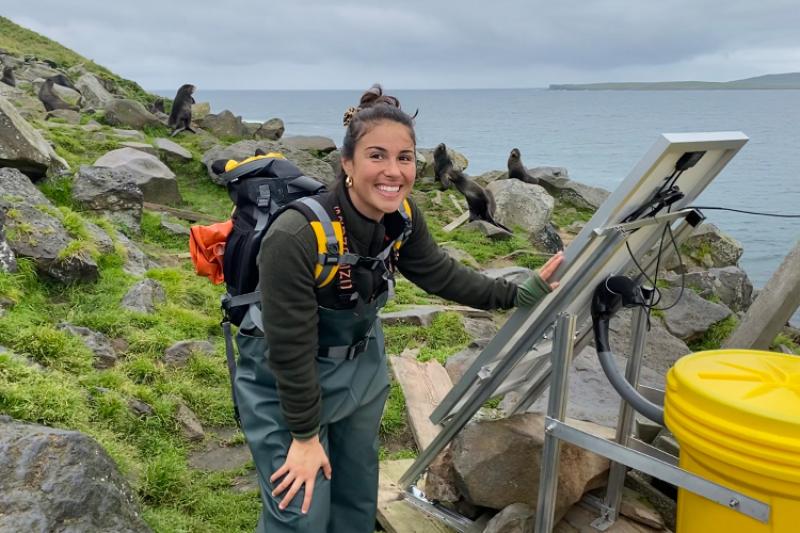 Photo of Kilali Gibson next to solar panels in Alaska.