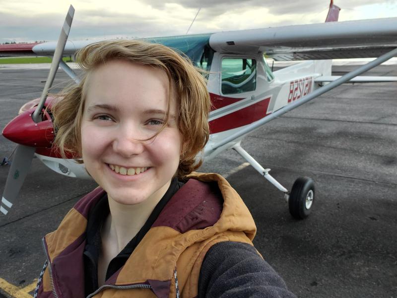 Headshot of Abi in front of a red and white Cessna 152.