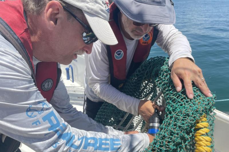 Gear team making real time adjustments to a turtle excluder device being tested.