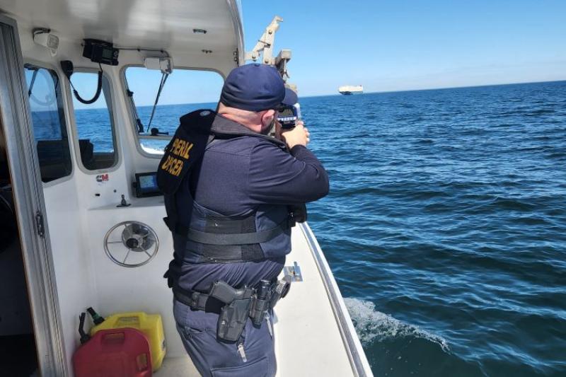 NOAA Enforcement Officer monitoring the vessel speed of a cargo ship.