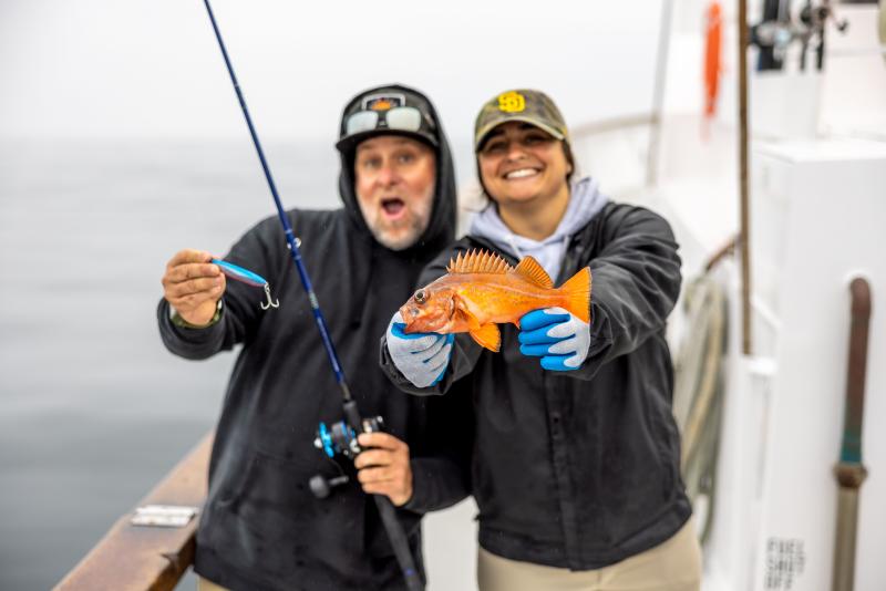 Anglers hold a vermillion rockfish. 