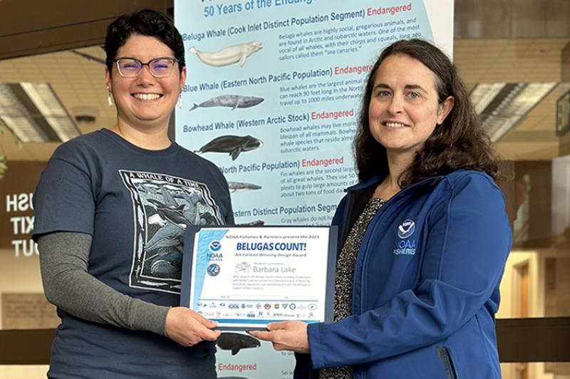 Belugas Count! poster design winner Barb Lake, of Juneau, accepts her award from Anne Marie Eich, head of the Alaska Region’s Protected Resources Division. Credit: NOAA Fisheries