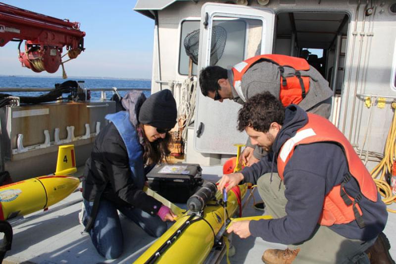 Crew setting up acoustic robots on deck.