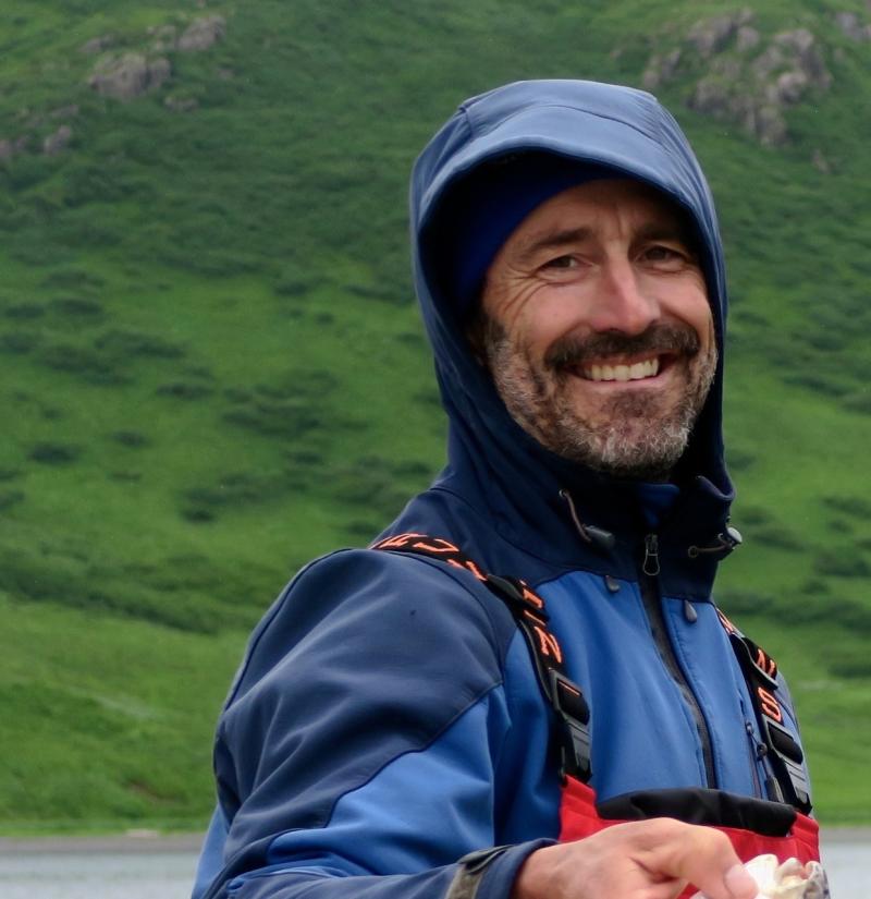 Portrait of man with blue coat with green hills in background