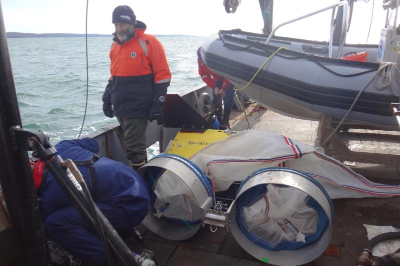 Harvey Walsh inspecting sampling gear, bongo nets, and zodiac on deck.