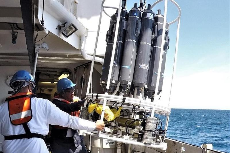 Two scientist pulling the CTD carousel back on board.