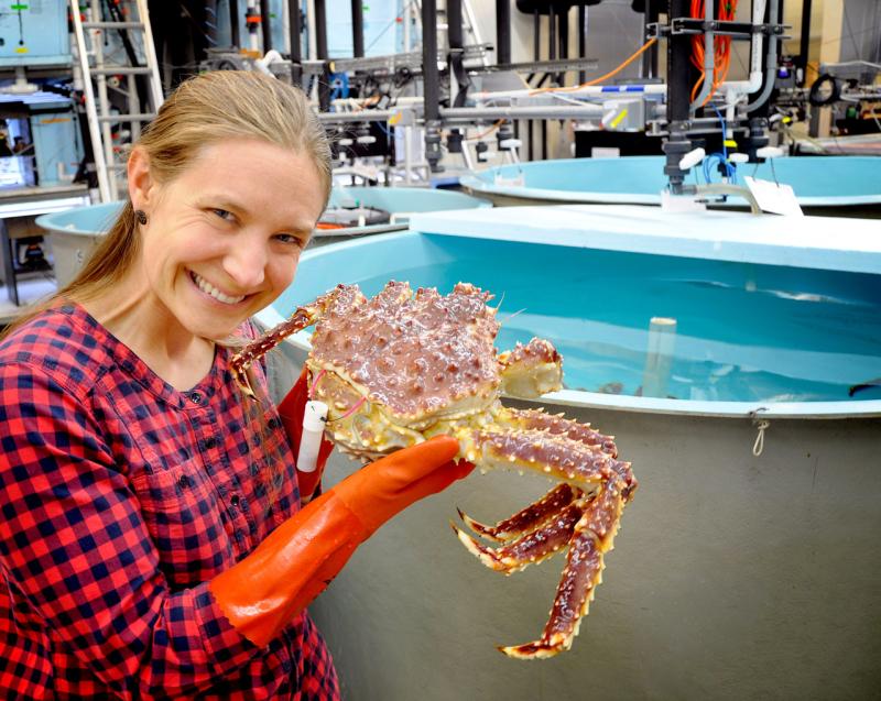 Woman holding crab near lab pools 